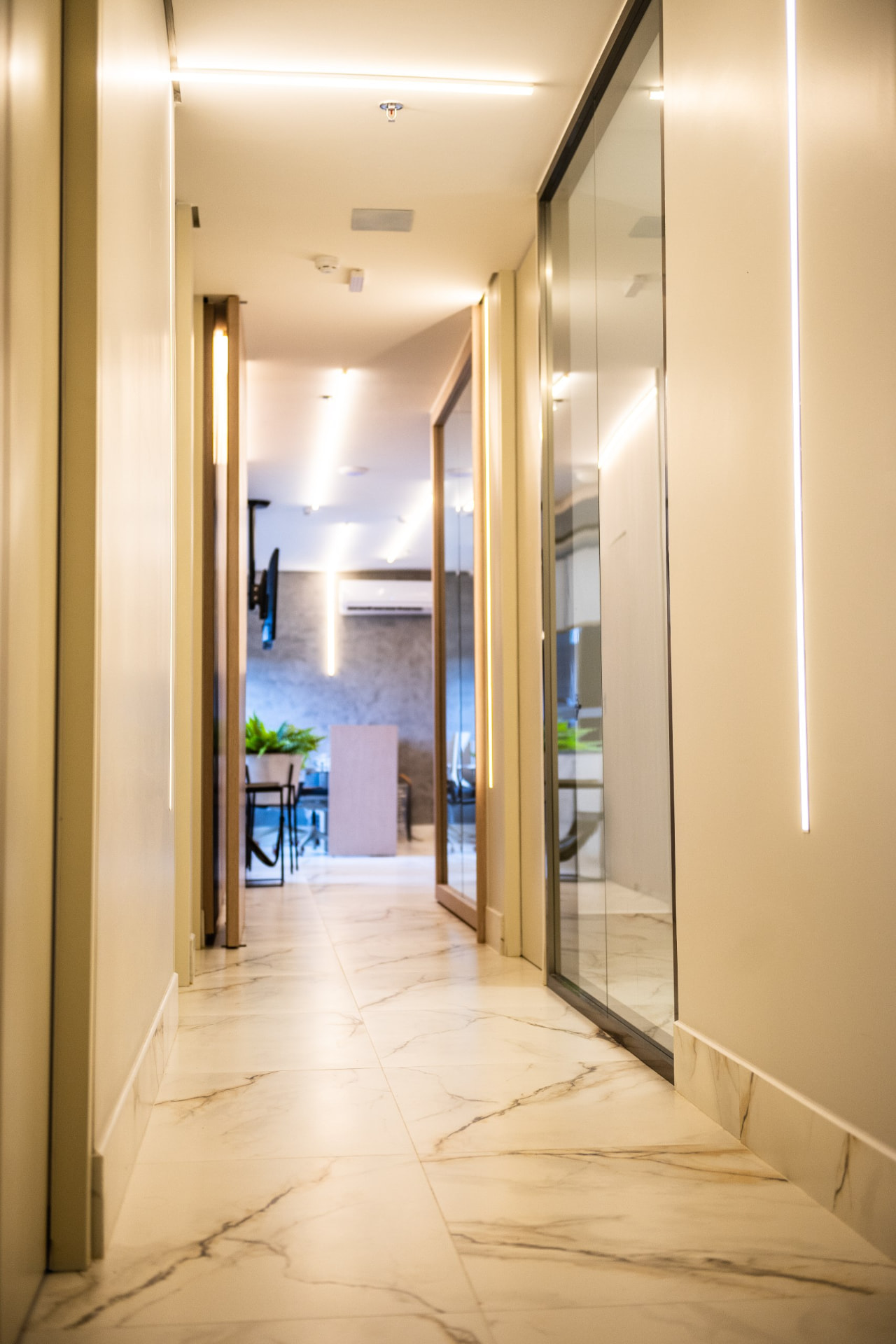 Corredor da BE Clinic Odontologia com piso de mármore e iluminação suave
